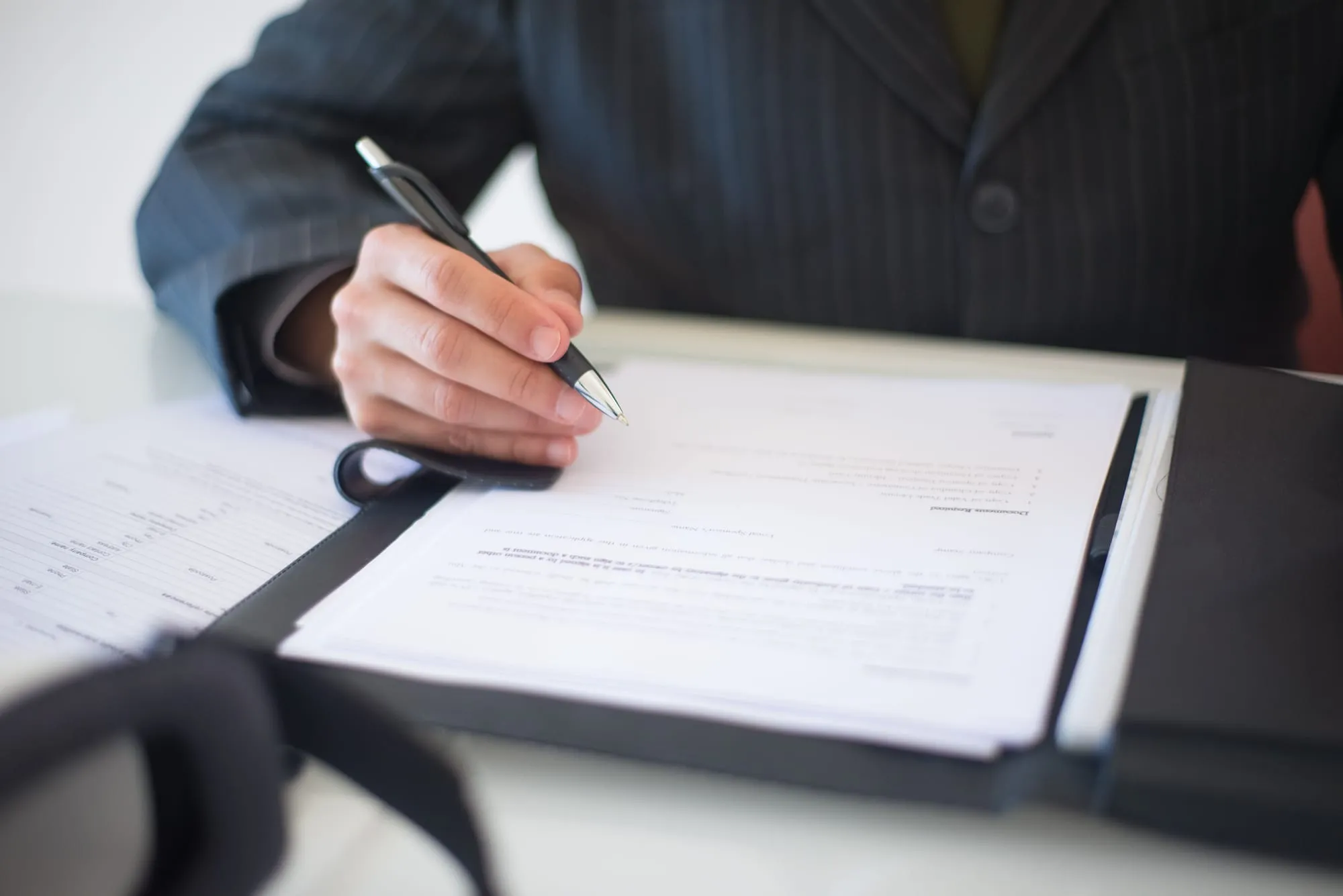 Client signing documents at a desk