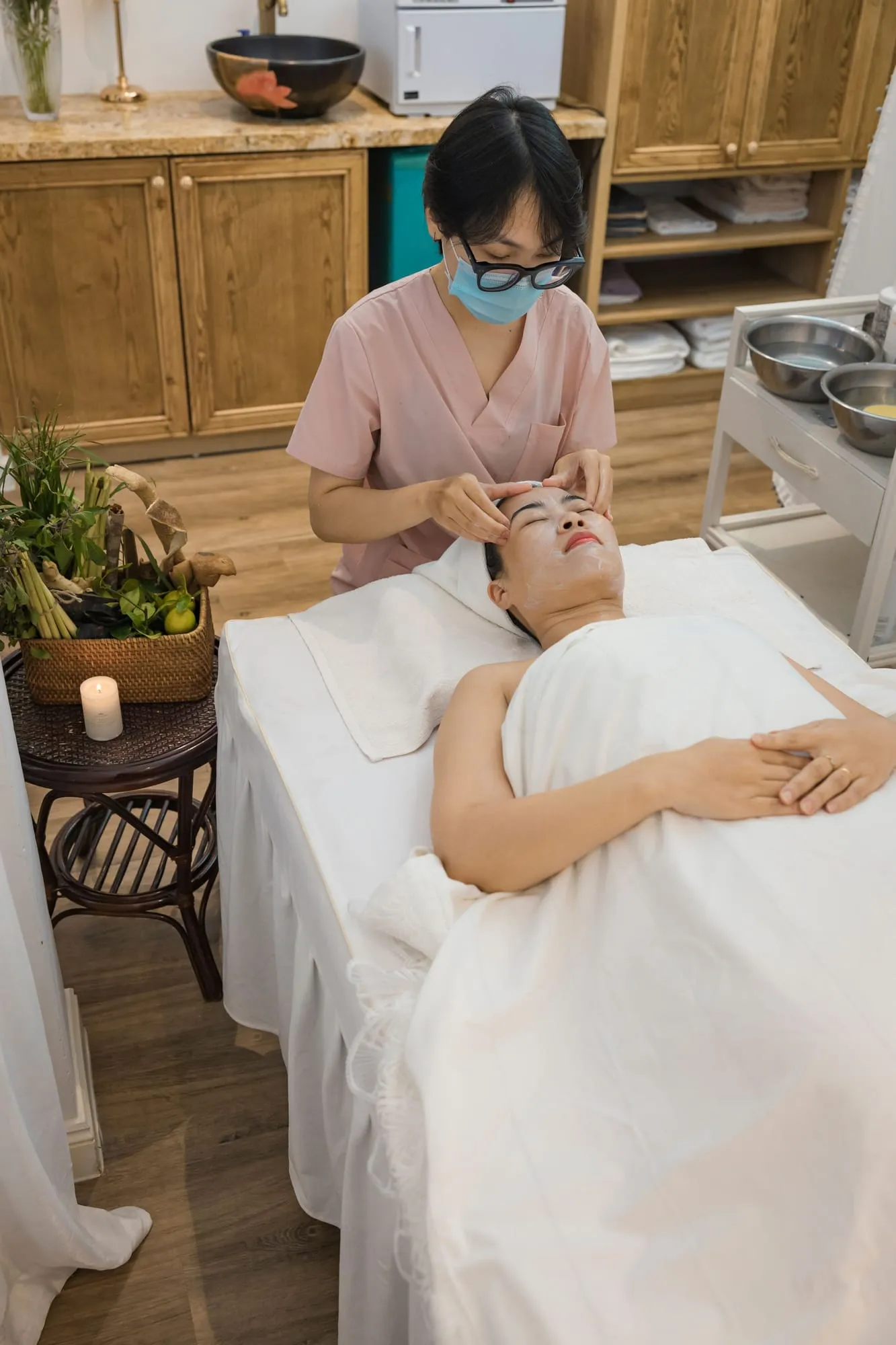 Client relaxing during a facial treatment by candlelight