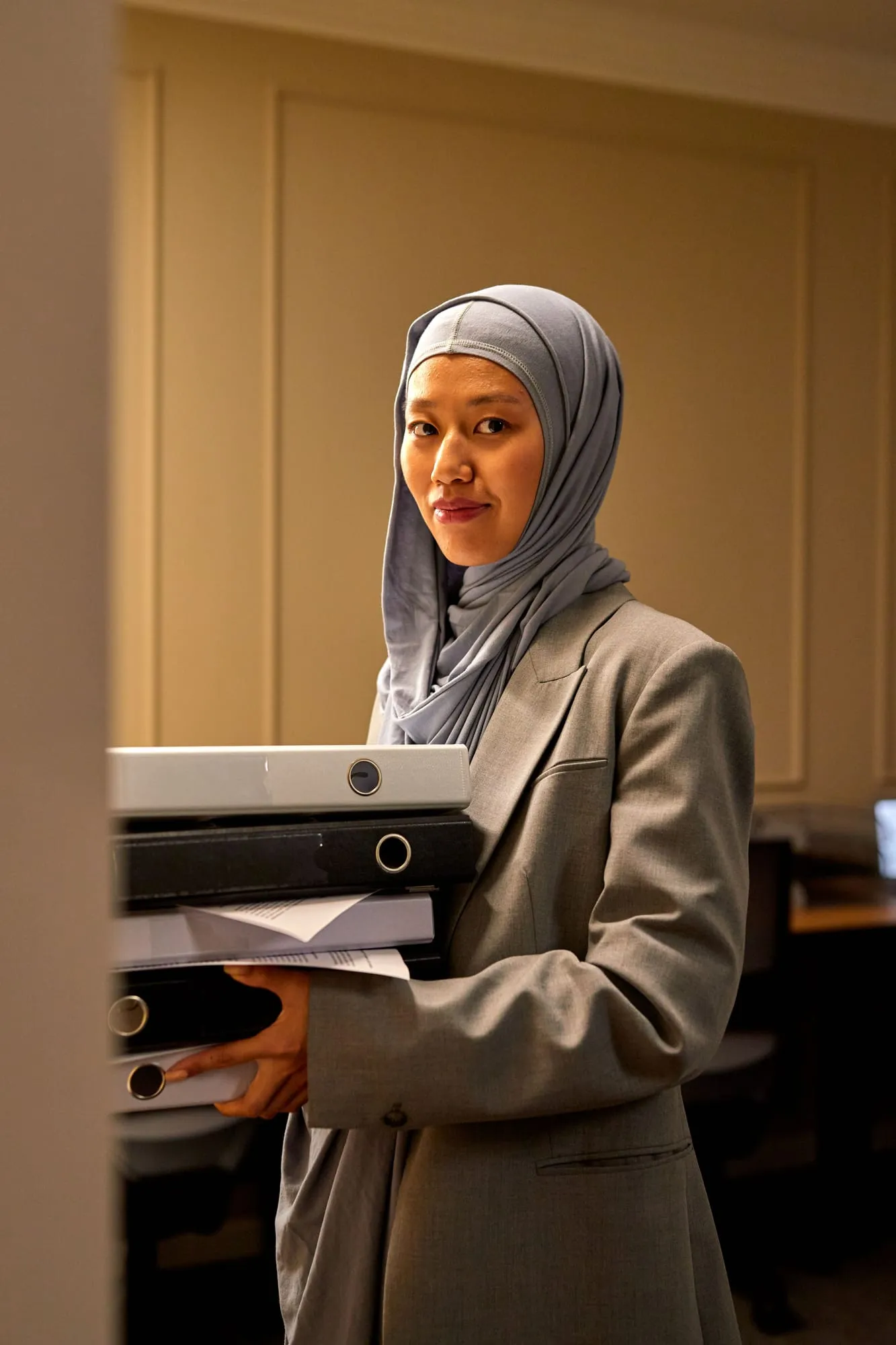 Portrait of a partner in a hijab and blazer at her desk