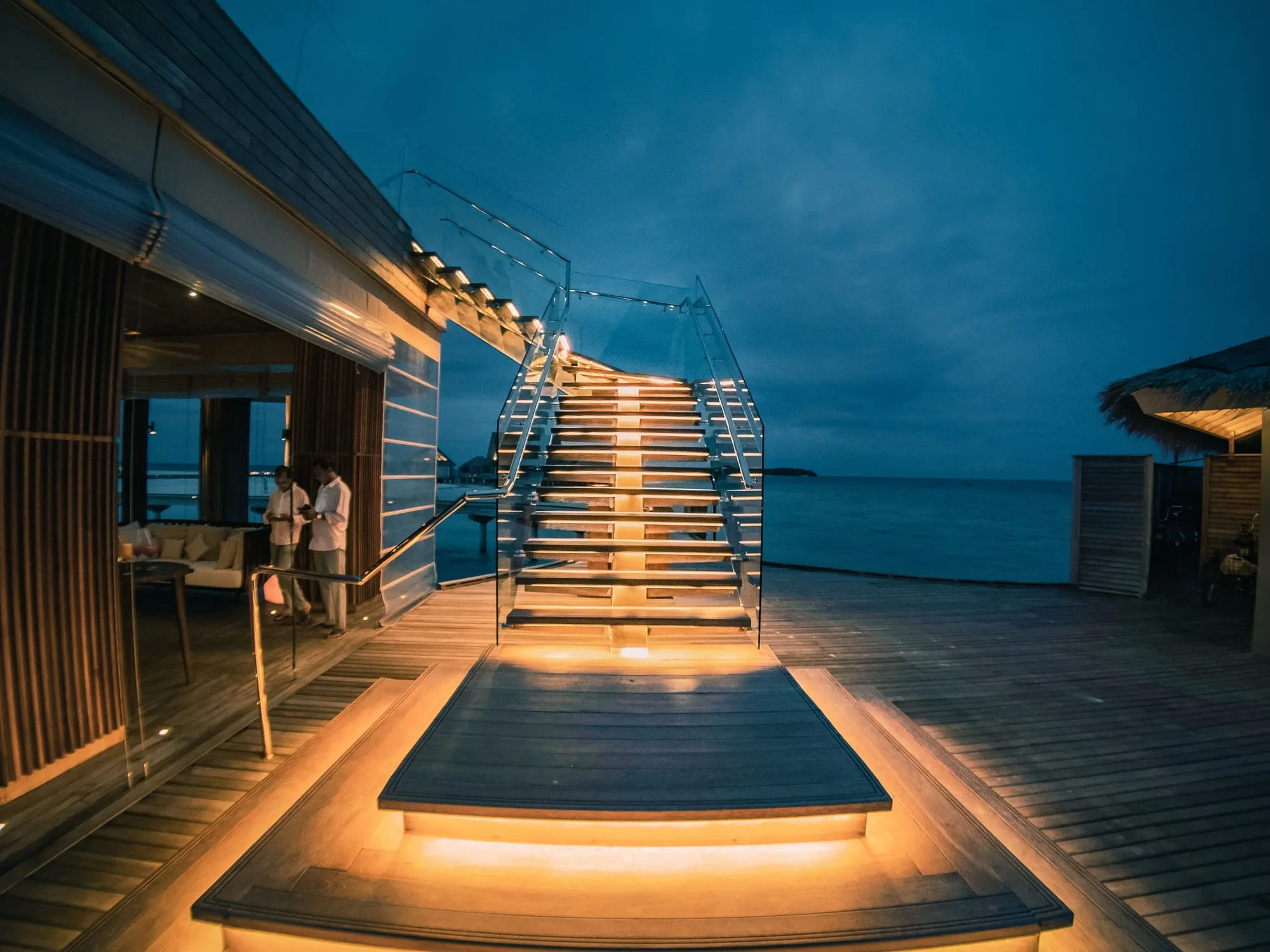 Lit steps leading down to the sea at dusk