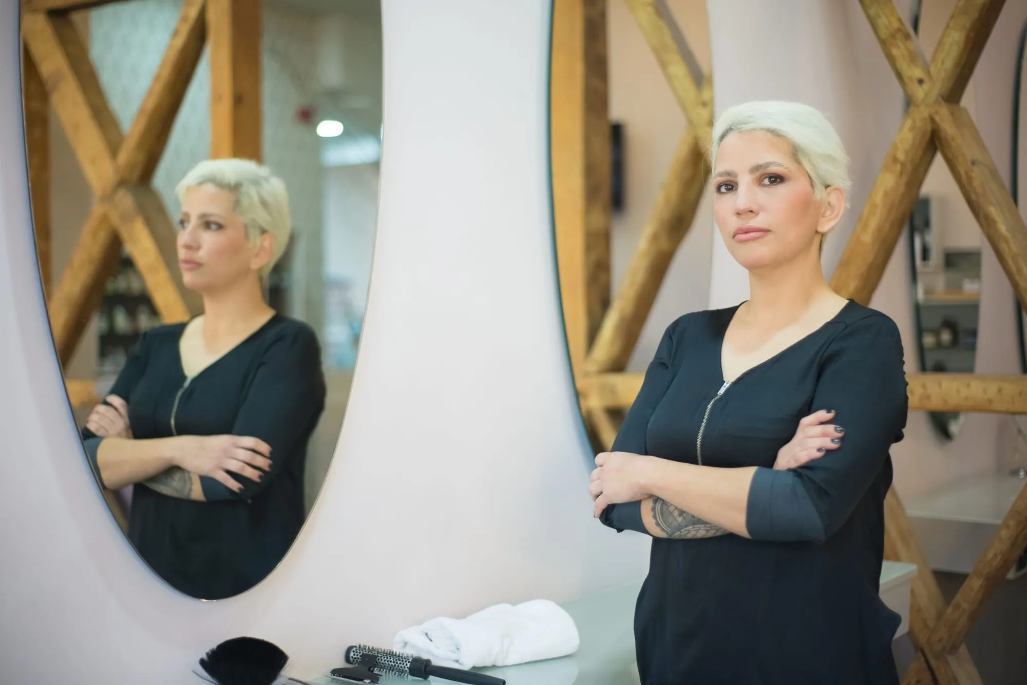 Salon founder standing beside a round mirror